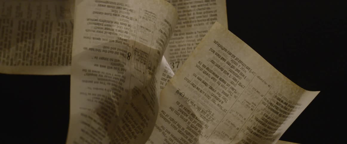 Crumpled book pages hanging in dark space