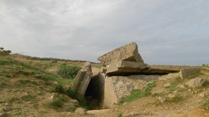 Crumbled and broken concrete slabs in a depression in a field