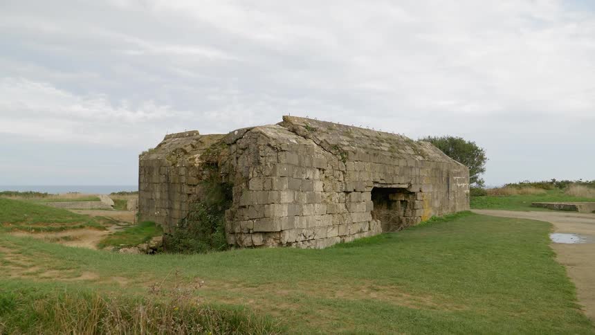 A scenery of a stone house in the middle of grass land
