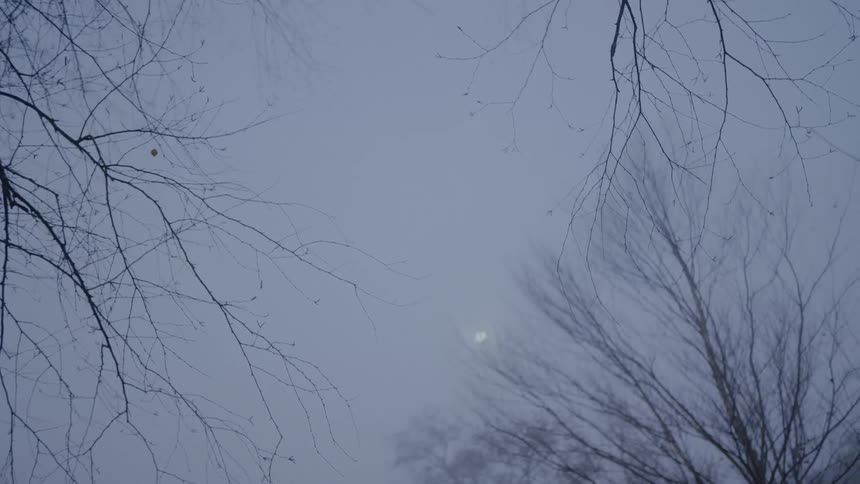 The moon obscured by dark and dreary overcast clouds