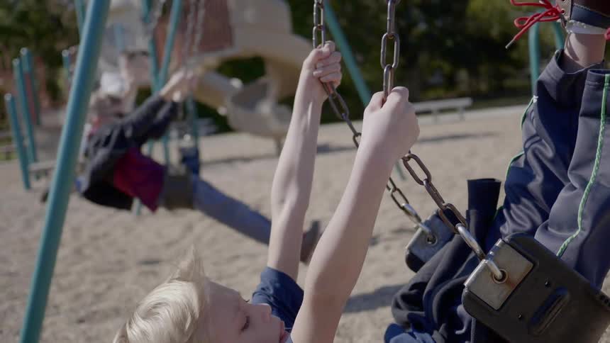 A group of children playing swing at the playground