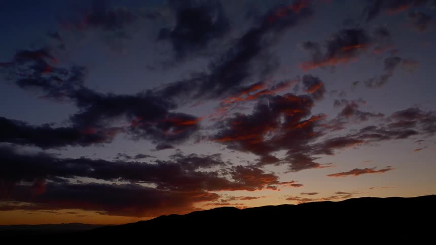 Time lapse of clouds moving across the mountain at sunrise