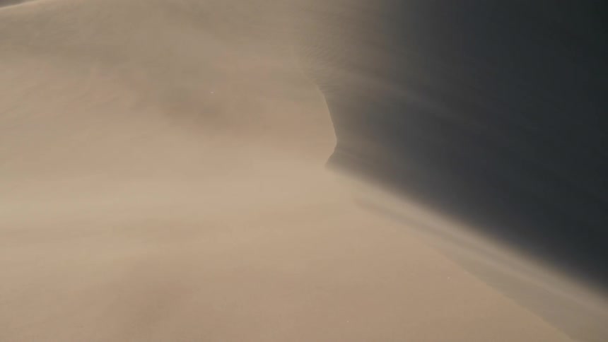 Wind blows the sand from the surface of the dunes