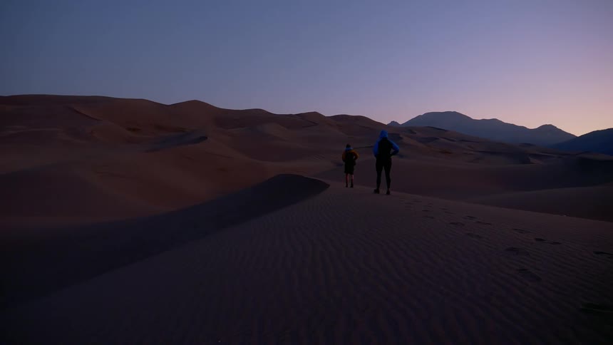 Two people hike in the desert together