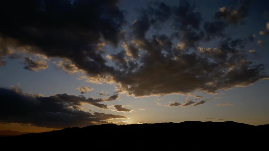 The sun starts to set creating shadows in the clouds above