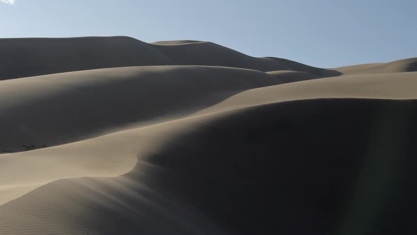 Wind blows the sand from the surface of the dunes
