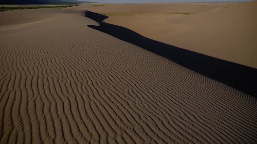 Sand dunes in a desert near a mountain