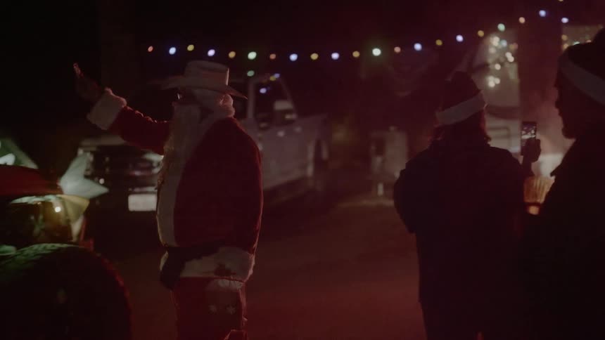 A man dressed as santa claus greets drivers on the road outside