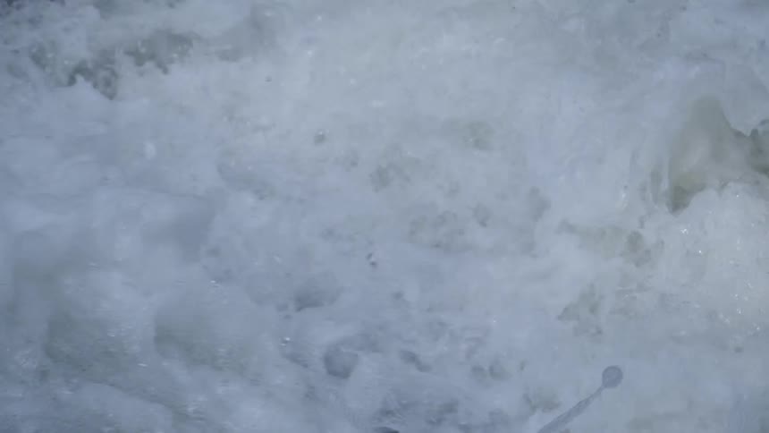 Water crashes over small dip then churns