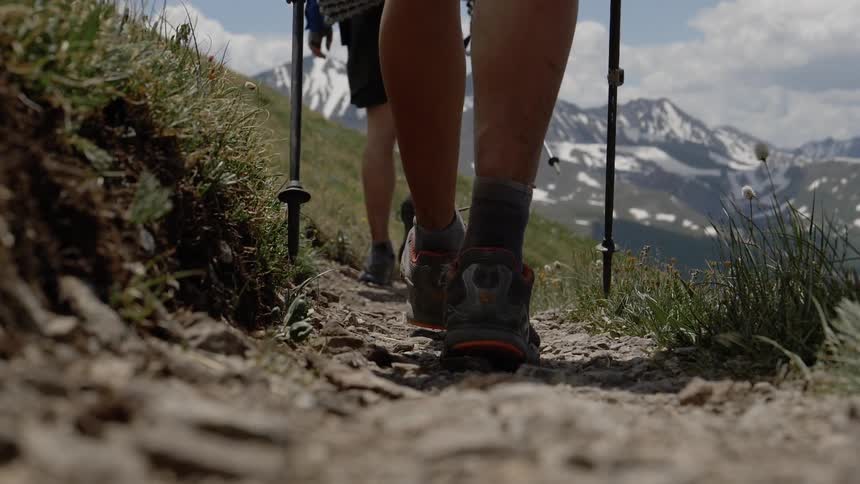Two people are hiking outdoors near mountains