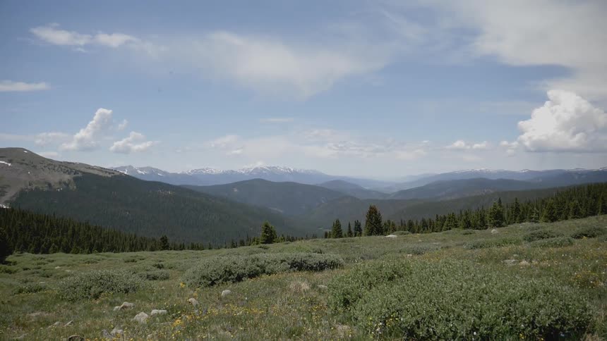 A grassy mountain side is part of a scenic range of mountains
