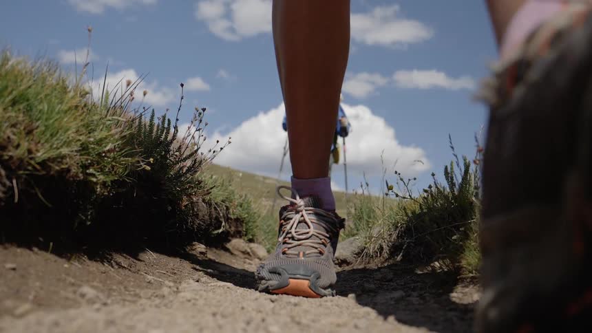 A footage of man walking towards the camera while hiking
