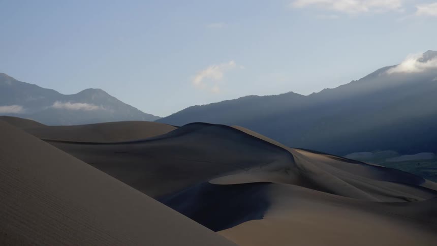 Wind blows the sand from the surface of the dunes