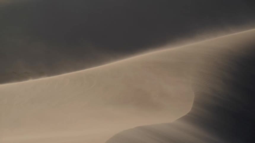 Wind blows the sand from the surface of the dunes