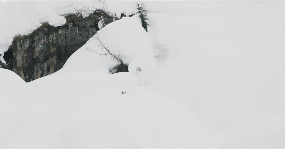 A person skis down the slope crashing through the snow