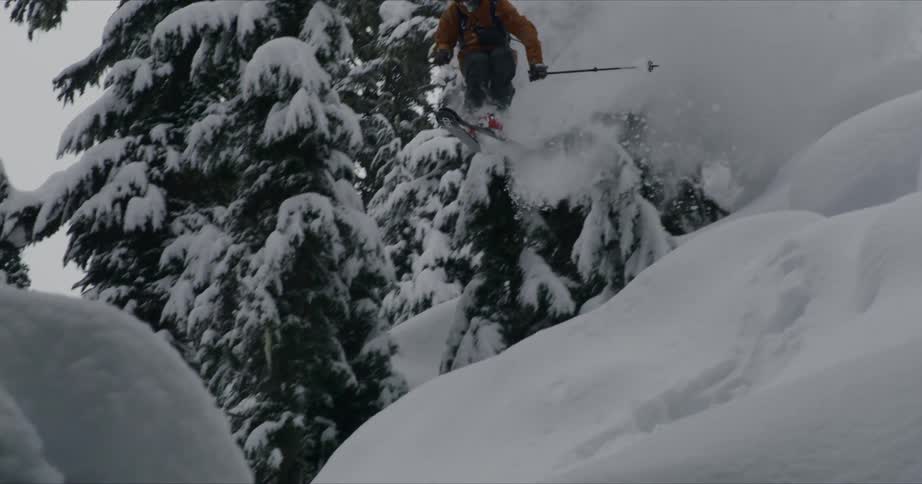A man doing a ski jump on the mountain