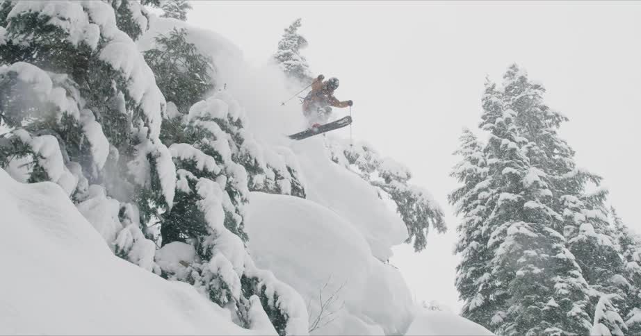 A scenery of a man jumping from mountain cliff with a snow board