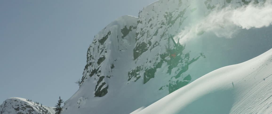 A person skis down a mountain and does a flip in the air
