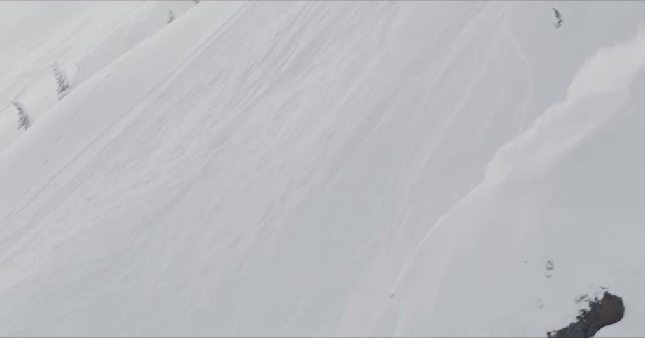 A man doing a downhill with his snowboard on the snowy mountain