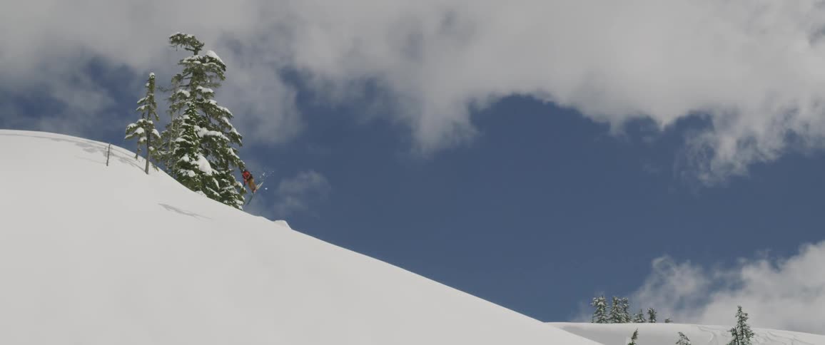 A person is skiing down a mountain covered in snow