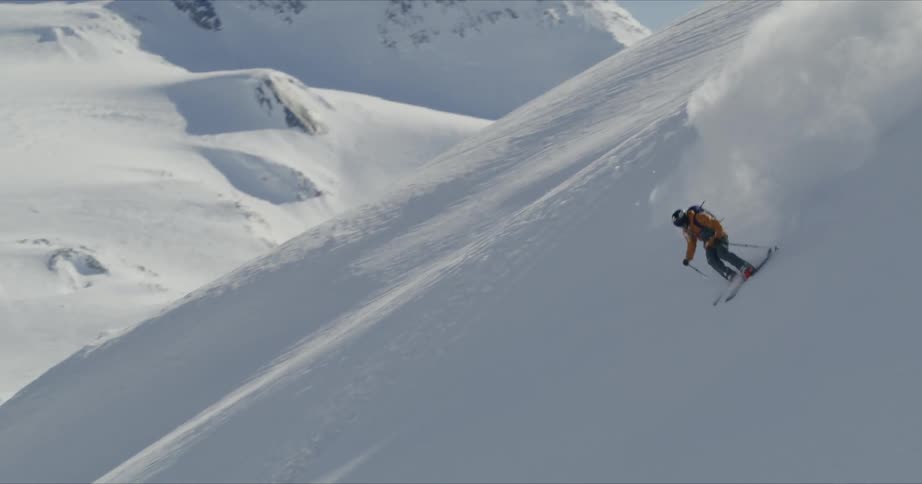 A person skis down a snowy slope
