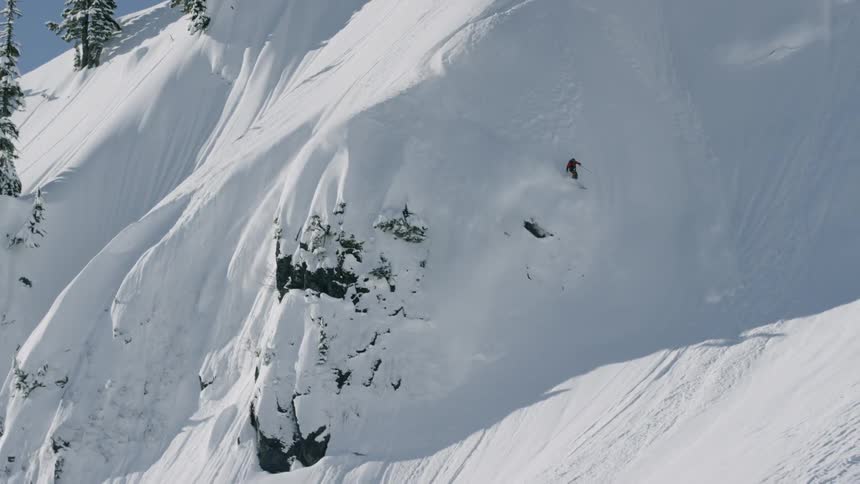 A person is skiing down a mountain in winter