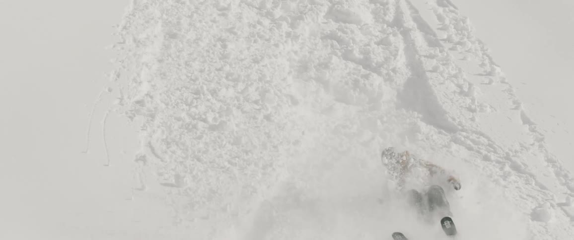 A person wipes out falling down the slope as they ski