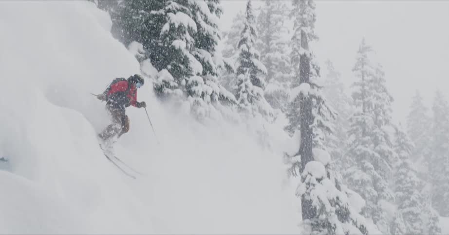 A person skis turbulently down a snowy mountain
