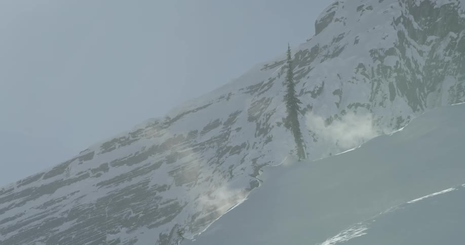 Wind blows over snow in mountains on a sunny day