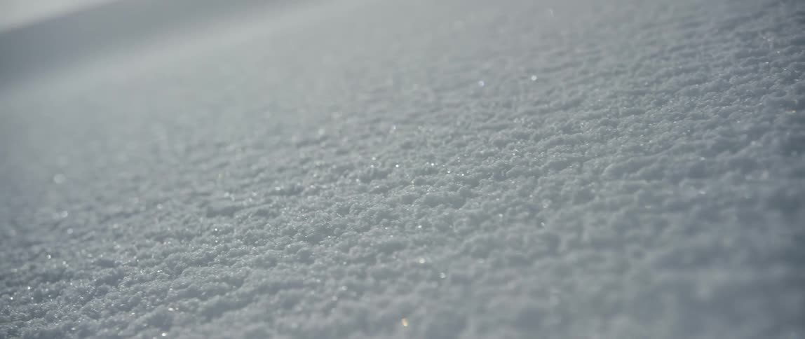 The camera moves over a surface covered with snow