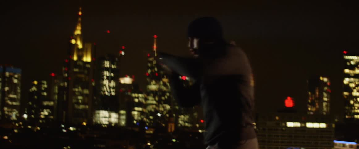 Boxer does the sport of boxing with cityscape in the background at night