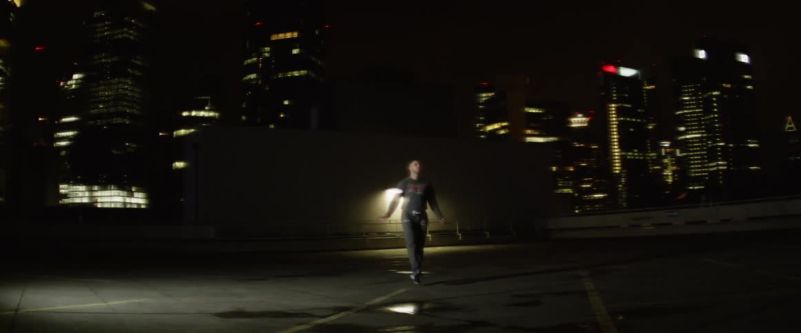 Man skips with a jump rope on a street in the dark