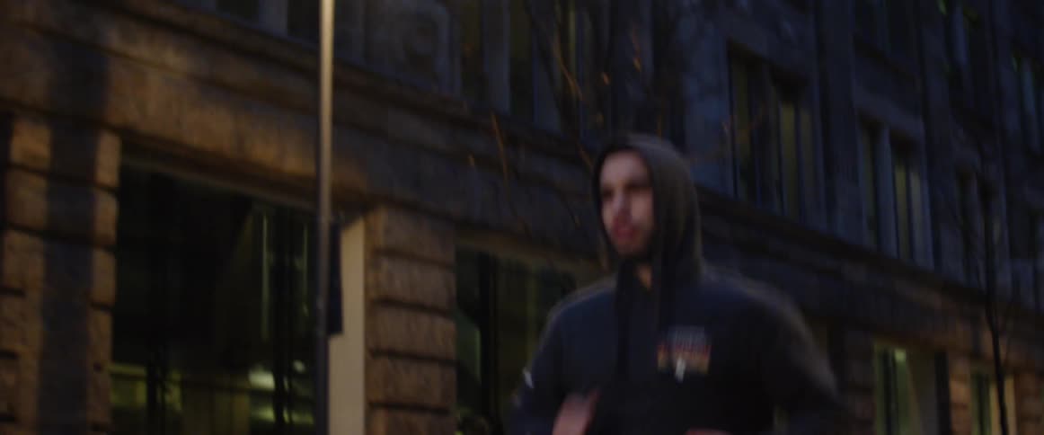 Man runs on road in the city at dawn