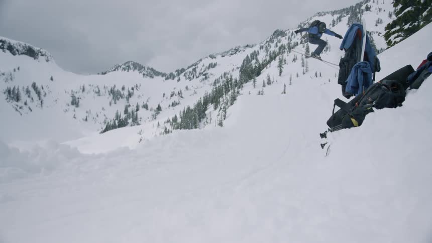 A skier is jumping off a ridge in a remote area on a winters day
