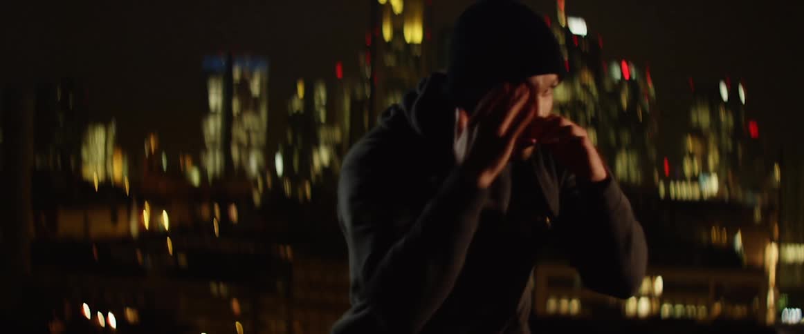 A man doing shadow boxing under the street light at night
