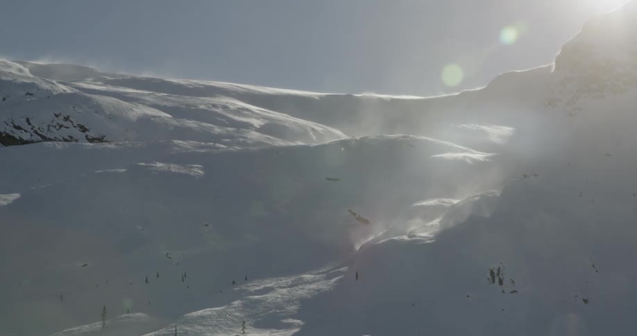 A scenery of a snowy mountain under the sun flare