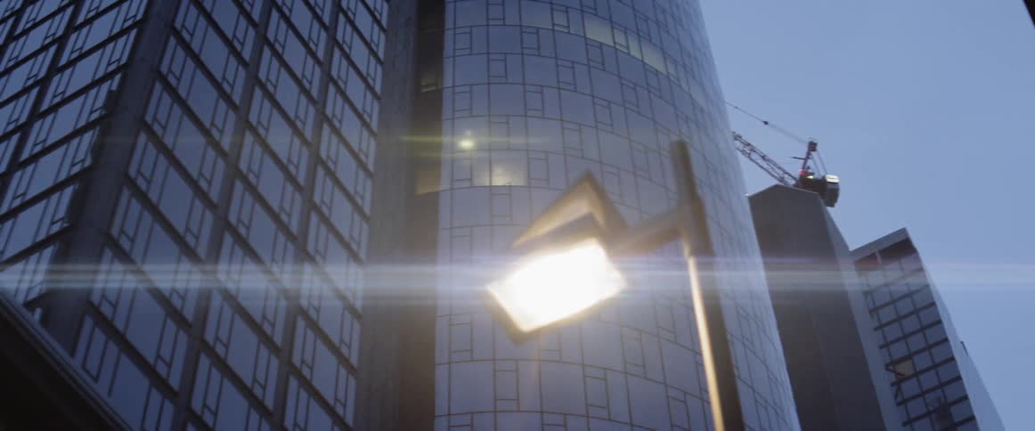 A crane sits atop a skyscraper in a metropolitan area