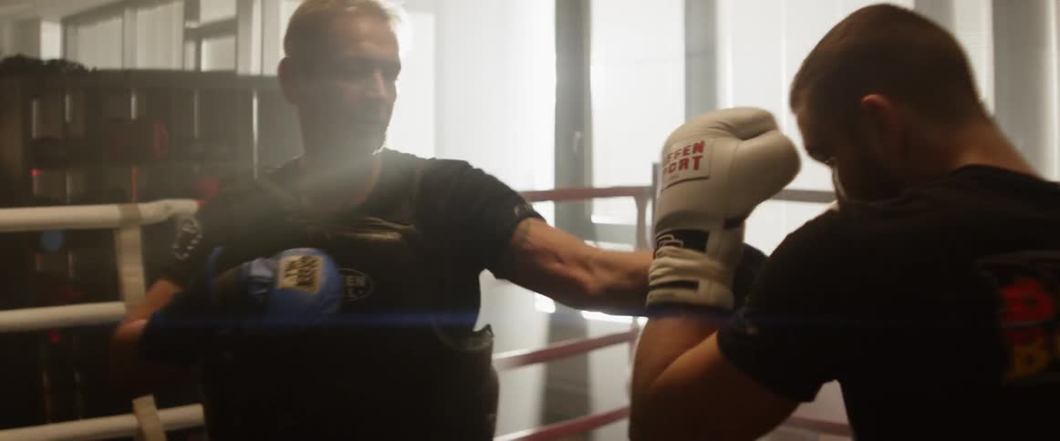 Two men boxing in a boxing ring at the gym