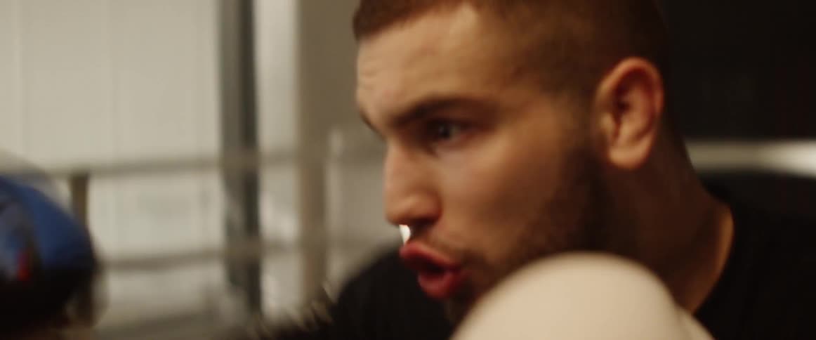 A man with boxing gloves in a boxing ring training