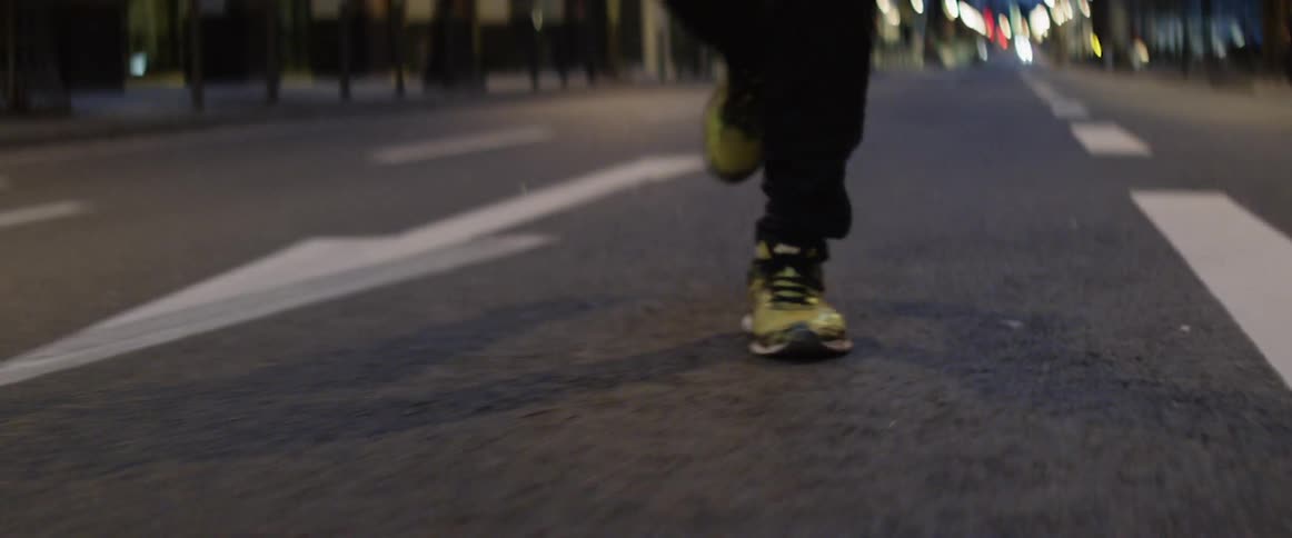 Man runs along the road in the city at dawn