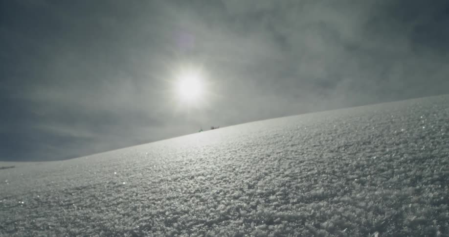 Powdery snow on a hillside glints during the daytime
