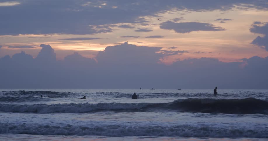 The sun is setting in the horizon above the ocean