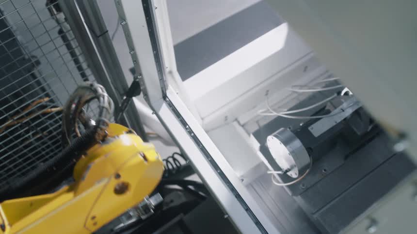 A yellow machine retracts from a cabinet
