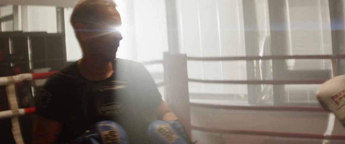Two men practice boxing moves in a boxing ring
