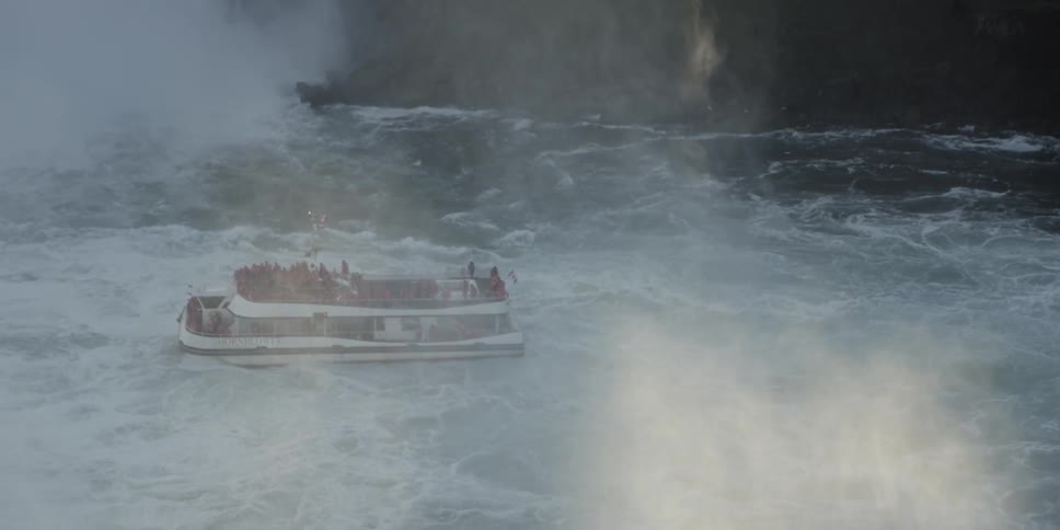 Ferry filled with tourists goes near waterfall