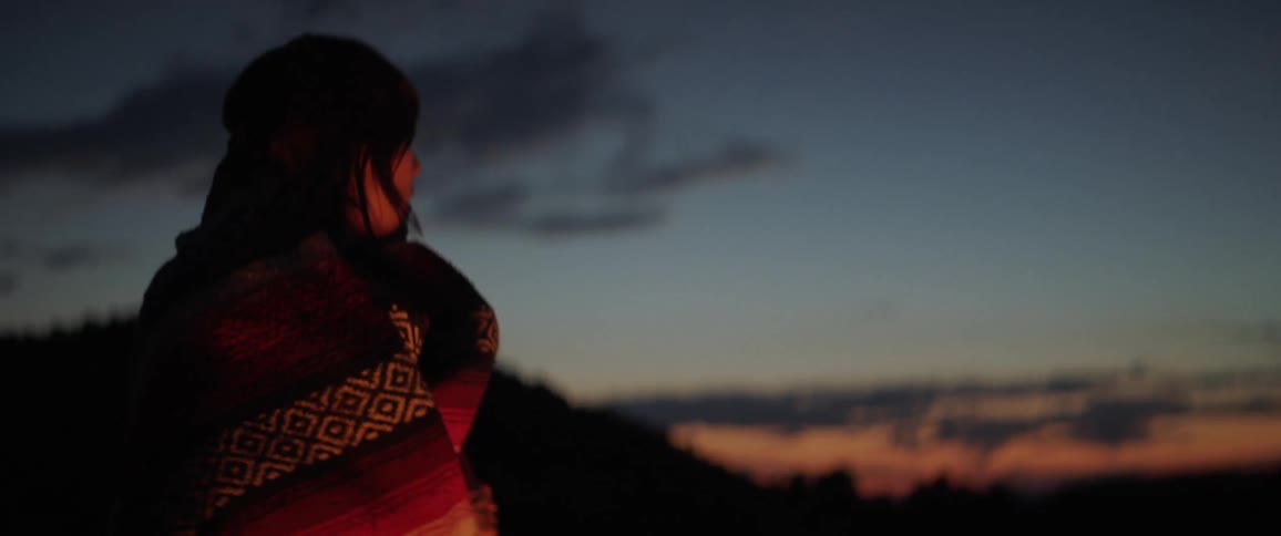 A footage of a woman looking into the dawn sky