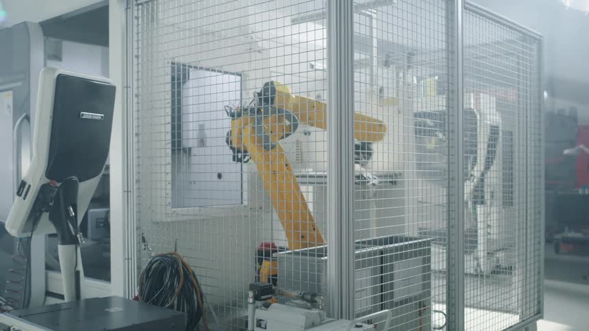 A footage of a robotic arm in a cage on the laboratory