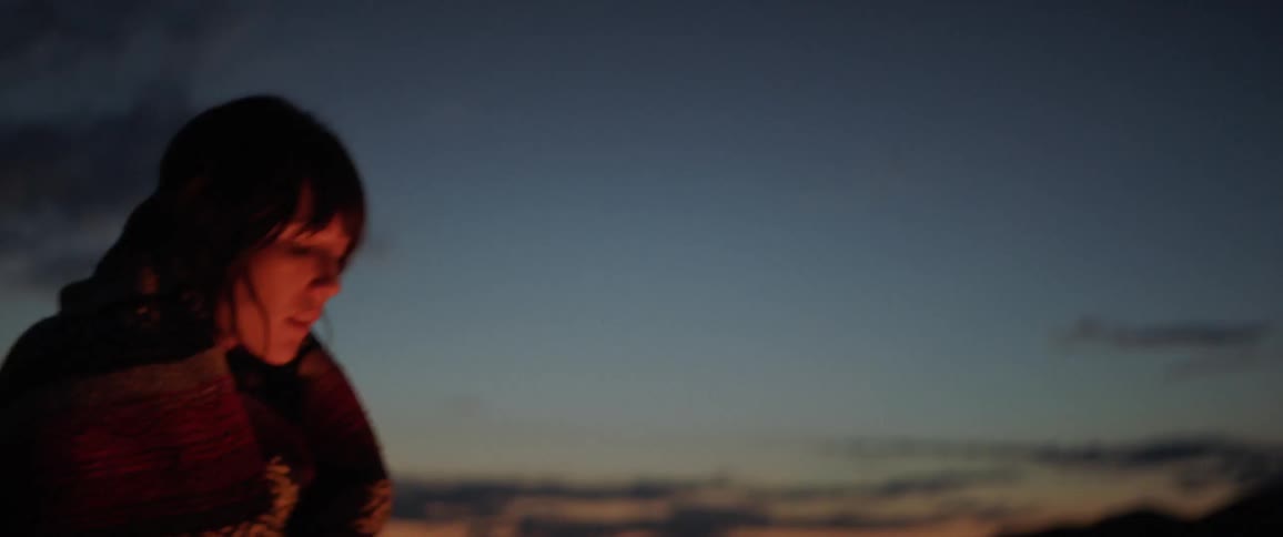 A woman is standing outdoors at night