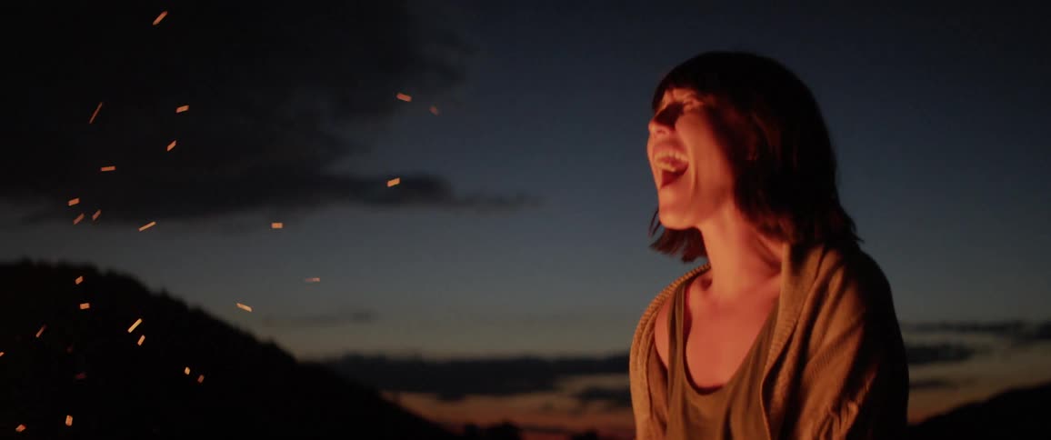 A young woman celebrate in front of a bonfire