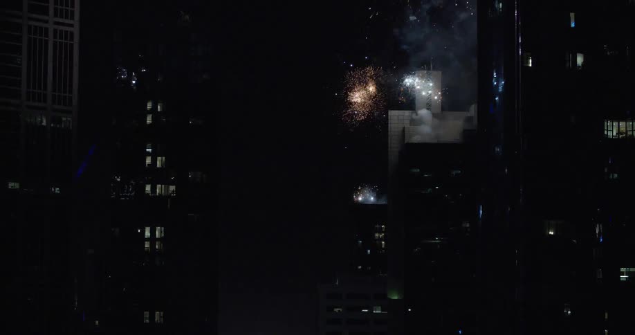 Fireworks are shot of on skyscraper roof at night